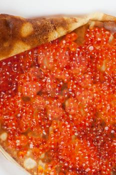 Pancake with red caviar closeup photo