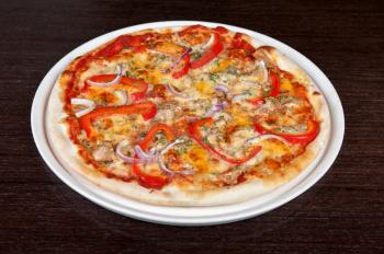 meat pizza with vegetables at the table