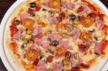 pizza with ham and mushrooms at the table