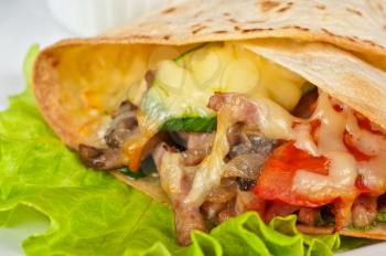 burrito with meat cheese and vegetables