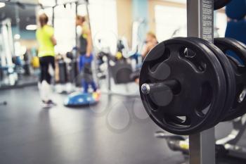 At the fitness modern gym with equipment. Disc weights on the foreground