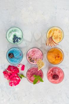 Different smoothie set on a white concrete background