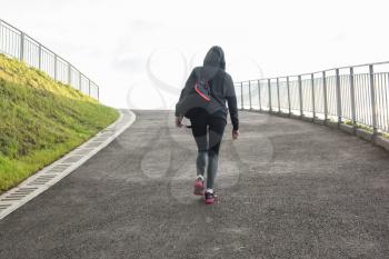 A woman in sportswear climbs the hill