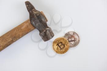 Bitcoin coins with hammer on the white background