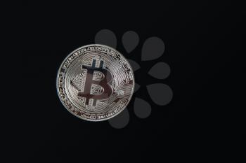 Silver Bitcoin coin on the black background