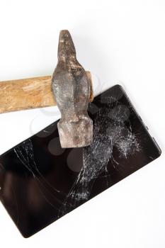 An old hammer and smartphone with broken screen on a white background