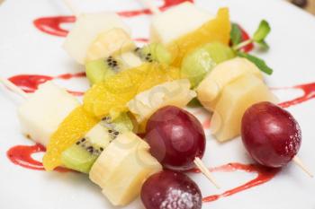 Food snack: cheese with grapes, kiwi, orange and banana