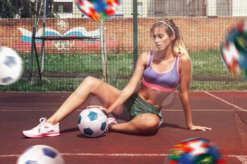 A young beauty athletic woman in sportswear with football ball outdoor. Concept of world soccer championship.