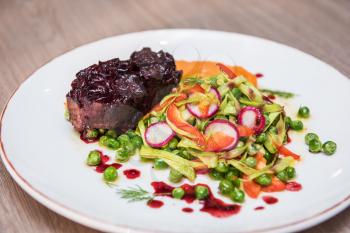 Roasted beef with berries sauce garnished with vegetables