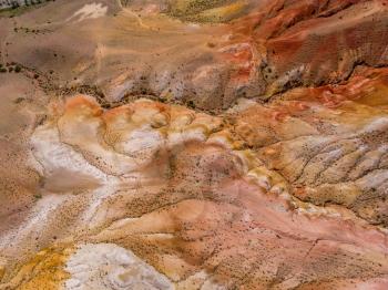 Aerial drone view of colorful eroded landform of Altai mountains with yellow, brown and red colors. Nature landscape in popular tourist location called Mars, near the border with Mongolia, Chagan-Uzun, Altai Republic, Russia