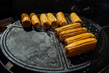 A professional cook prepares corn on the grill outdoor, food or catering concept
