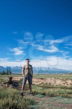 Relaxing man in Kurai steppe on North-Chui ridge background. Altai mountains, Russia.
