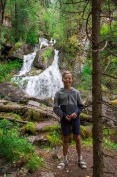 Young boy at waterfall in Altai Mountains territory