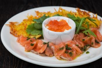 Plate with potato pancakes salmon fish and red caviar