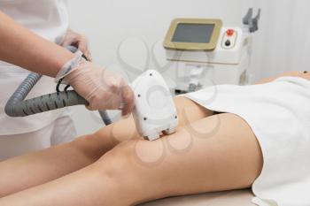 Laser epilation of legs, hair removal cosmetology procedure. Health and beauty concept.