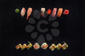 Various kinds of sushi served on wood black table. Concept of sushi menu for Japanese food