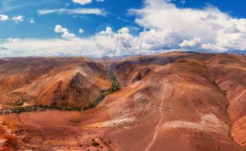 Aerial drone panorama of colorful eroded landform of Altai mountains with yellow, brown and red colors. Nature landscape in popular tourist location called Mars, near the border with Mongolia, Chagan-Uzun, Altai Republic, Russia