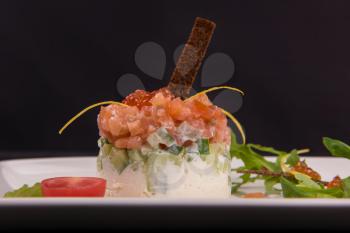 Fresh salmon tartare with vegetable red caviar arugula and rusk