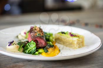 Beef meat with green peas, sweet potato mousse, roasted spinach and zucchini gratin