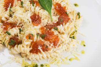 Pasta with parmesan cheese basil and red caviar. The concept of Italian cuisine.