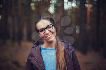 Art portrait of pretty happy woman posing in forest and looking at camera. Shallow DOF.
