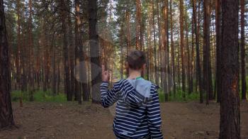 Following a boy running in a forest, gimbal shot