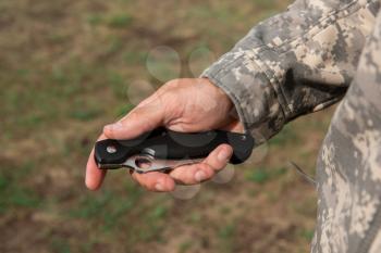 A man with a knife in the forest. Travel or military concept