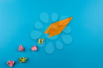 Flat lay of color paper plane on blue color paper background. Business for innovative solutionor air travel concept