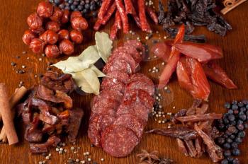 different sausage and meat on a celebratory table with spices and vegetables