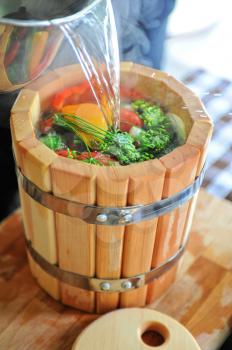 preserving tomatoes, cucumbers, peppers in wooden jar