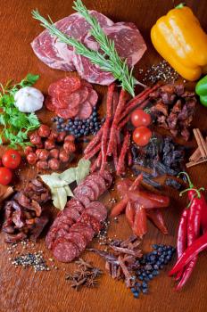 different sausage and meat on a celebratory table with spices and vegetables