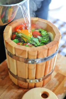 preserving tomatoes, cucumbers, peppers in wooden jar