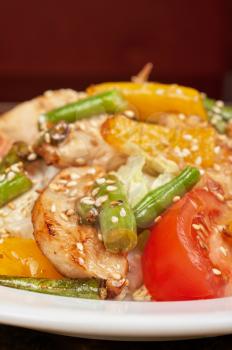 Warm salad with chicken, vegetable and sesame seeds