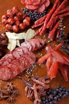 different sausage and meat on a celebratory table with spices and vegetables