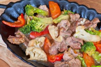 meat with vegetables at frying pan