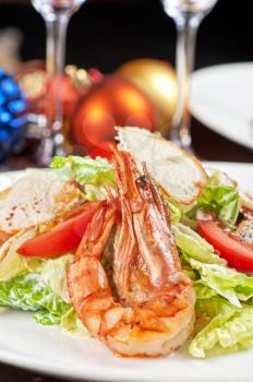 Tasty shrimp salad with vegetables on christmas table