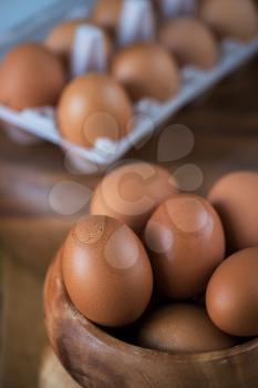 Fresh eggs at wooden plate closeup