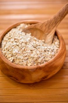 Oat flakes with at wooden plate on wooden background