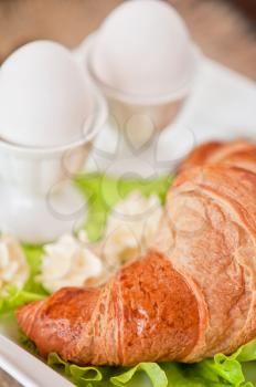 Tasty breakfast from eggs and croissant