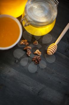 Honey with walnut on wooden background