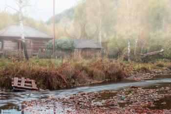 Autumn at mountain village. Morning fog at river