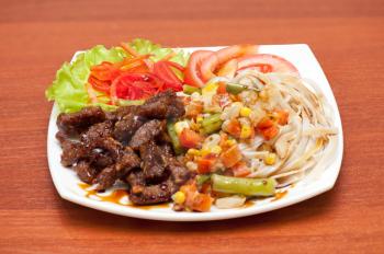 plate of chinese noodles with roasted meat and vegetables