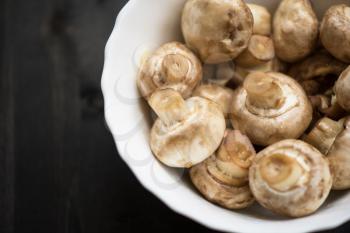 Fresh mushrooms champignons on plate close up