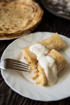 Fried pancakes  with sour cream on old wooden table