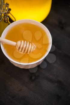 Honey with walnut on wooden background