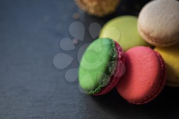French colorful macarons on black background