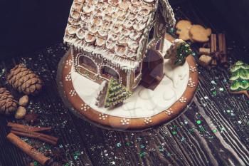 gingerbread house for new years and christmas on wooden background, xmas theme