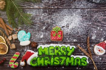 Different ginger cookies for new years and christmas on wooden background, top view