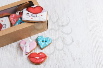 Gingerbreads for Valentines Day in gift box on white wooden background