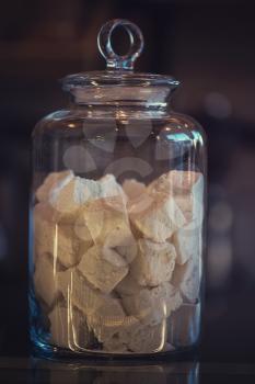 Marshmallows in glass jar, closeup photo